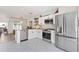 Bright kitchen features stainless steel appliances, white cabinets, patterned tile floor, and breakfast bar that opens to the living area at 4859 Napoli Ne Ct # 4859, St Petersburg, FL 33703