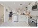 Well-lit kitchen with stainless steel appliances, white cabinetry, patterned floor, and an open design layout to the adjacent living room at 4859 Napoli Ne Ct # 4859, St Petersburg, FL 33703