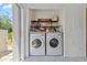 Convenient laundry room with washer, dryer, open shelving for storage, and easy access to the outdoors at 4859 Napoli Ne Ct # 4859, St Petersburg, FL 33703