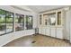 Bright dining area featuring wood floors, paneled walls, and large windows with built-in cabinets at 5832 Sussex Dr, Tampa, FL 33615
