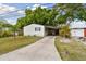 Charming single-story home with a long driveway and carport nestled amidst lush greenery and mature trees at 5832 Sussex Dr, Tampa, FL 33615