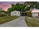 Charming home with a well-maintained lawn, long driveway, carport, and a lovely small tree at 5832 Sussex Dr, Tampa, FL 33615