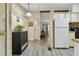 Open-concept kitchen with laminate floors, white appliances, and a functional layout connecting to other rooms at 5832 Sussex Dr, Tampa, FL 33615