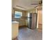 Well-lit kitchen featuring stainless steel refrigerator, neutral countertops and cabinets, and modern fixtures at 6420 N Thatcher Ave, Tampa, FL 33614
