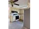 Traditional kitchen with white cabinetry, black appliances, and speckled flooring creating a functional space at 6420 N Thatcher Ave, Tampa, FL 33614