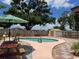 Inviting backyard pool with mature trees and picnic table, perfect for outdoor entertaining and relaxation at 6420 N Thatcher Ave, Tampa, FL 33614