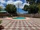 Backyard pool with patterned tile, diving board, privacy fence, and decorative perimeter gravel at 6420 N Thatcher Ave, Tampa, FL 33614
