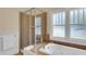 Bathroom featuring a tiled shower, soaking tub, and a bright, frosted window for privacy at 7701 N Dartmouth Ave, Tampa, FL 33604