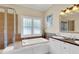 Bright bathroom features a soaking tub, walk-in shower, and double vanity with elegant fixtures at 7701 N Dartmouth Ave, Tampa, FL 33604