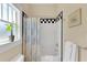 Well-lit bathroom featuring a shower with a patterned curtain and tile and a large window at 7701 N Dartmouth Ave, Tampa, FL 33604