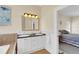 Bathroom vanity area with double sinks, granite counters, and a view to the bedroom at 7701 N Dartmouth Ave, Tampa, FL 33604