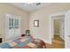 Comfortable bedroom with a colorful quilt, natural light, and hardwood floors at 7701 N Dartmouth Ave, Tampa, FL 33604