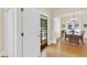 Bright dining room featuring hardwood floors, white trim, and natural light from the door and windows at 7701 N Dartmouth Ave, Tampa, FL 33604