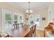 Traditional dining room with a large wooden table, chandelier, and windows with shutter-style blinds at 7701 N Dartmouth Ave, Tampa, FL 33604