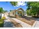 This charming home features a long driveway leading to a detached garage, surrounded by lush greenery at 7701 N Dartmouth Ave, Tampa, FL 33604
