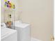 A functional laundry area with shelving, a washer, and a dryer ready for use at 7701 N Dartmouth Ave, Tampa, FL 33604