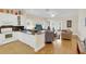 Open concept living room featuring bright kitchen, wood floors, and abundant natural light at 7701 N Dartmouth Ave, Tampa, FL 33604
