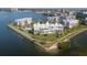 Aerial shot of waterfront condo buildings with lush lawns, mature palms, pool and boat docks at 8020 Sailboat Key S Blvd # 101, St Pete Beach, FL 33707