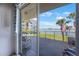 Balcony with chairs overlooking the water, palm trees, and clear skies at 8020 Sailboat Key S Blvd # 101, St Pete Beach, FL 33707