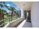 Balcony view of the building and its surrounding landscape with palm trees, blue skies, and the kitchen at 8020 Sailboat Key S Blvd # 101, St Pete Beach, FL 33707