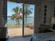 View from the bedroom balcony of palm trees, the water, and blue skies at 8020 Sailboat Key S Blvd # 101, St Pete Beach, FL 33707