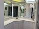 Bathroom featuring a large mirror, tiled countertop, cabinets, and open access to the shower at 8020 Sailboat Key S Blvd # 101, St Pete Beach, FL 33707