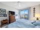 Bedroom with blue bedding, a dresser, a TV, and access to a balcony with water views at 8020 Sailboat Key S Blvd # 101, St Pete Beach, FL 33707