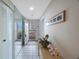 Bright hallway with tiled floors, mirrored closet doors, and access to a sunny balcony with ocean views at 8020 Sailboat Key S Blvd # 101, St Pete Beach, FL 33707