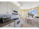 Eat-in kitchen featuring white cabinets, granite countertops, and stainless steel appliances at 8020 Sailboat Key S Blvd # 101, St Pete Beach, FL 33707