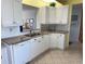 Bright open-concept kitchen featuring white cabinets, granite countertops and an adjacent living area at 8020 Sailboat Key S Blvd # 101, St Pete Beach, FL 33707