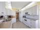 Bright kitchen featuring white cabinets, tile floors, and granite countertops at 8020 Sailboat Key S Blvd # 101, St Pete Beach, FL 33707