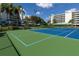Community tennis courts with trees and buildings in the background at 8020 Sailboat Key S Blvd # 101, St Pete Beach, FL 33707