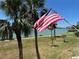Water view featuring the American flag, palm trees and walking path below at 8020 Sailboat Key S Blvd # 101, St Pete Beach, FL 33707