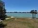 Waterfront view of the coast with lush lawns, mature palms and sidewalk in a desirable neighborhood at 8020 Sailboat Key S Blvd # 101, St Pete Beach, FL 33707