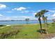 Beautiful waterfront views with lush lawns, mature palms and sidewalk along the water at 8020 Sailboat Key S Blvd # 101, St Pete Beach, FL 33707