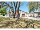 Single-Gathering home with attached garage, stone accents, and mature trees in the front yard at 8902 N Hamner Ave, Tampa, FL 33604
