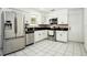 Modern kitchen with stainless steel appliances, granite countertops, white cabinets, and tile flooring at 8902 N Hamner Ave, Tampa, FL 33604