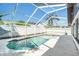 Screened-in pool with built-in spa surrounded by concrete patio with white fencing at 8902 N Hamner Ave, Tampa, FL 33604