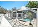 Screened-in pool with bright white patio and partial house view with multiple windows at 8902 N Hamner Ave, Tampa, FL 33604