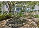Community courtyard featuring a rock fountain, lush landscaping, covered seating, and walkways at 946 Highland Ave # 23, Dunedin, FL 34698