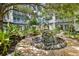 Beautiful landscaped common area features mature trees, a tranquil fountain, and benches for relaxation at 946 Highland Ave # 23, Dunedin, FL 34698
