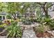Beautiful common area with lush landscaping and central water feature near condo buildings with white balconies at 946 Highland Ave # 23, Dunedin, FL 34698