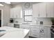 Kitchen featuring white cabinets, stainless steel appliances, quartz countertops, and breakfast bar at 946 Highland Ave # 23, Dunedin, FL 34698
