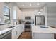 Bright kitchen featuring white cabinets, stainless steel appliances, quartz countertops, and center island at 946 Highland Ave # 23, Dunedin, FL 34698