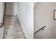 A carpeted staircase with a modern handrail leads to the next level in this neutral toned home at 946 Highland Ave # 23, Dunedin, FL 34698