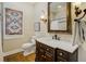 Well-lit bathroom with a dark wood vanity with marble top, modern fixtures, and patterned window treatment at 1102 Palm View Ave, Belleair, FL 33756