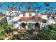 Elegant home with a red tile roof and white walls, surrounded by lush greenery at 1102 Palm View Ave, Belleair, FL 33756