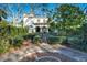 Elegant home featuring a manicured front yard with stone pathway and lush landscaping at 1102 Palm View Ave, Belleair, FL 33756
