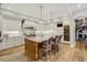 Bright kitchen with white cabinets, a large island, pendant lighting, and wine storage at 1102 Palm View Ave, Belleair, FL 33756