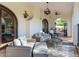 Covered outdoor living space with comfortable seating, a chandelier, and arched doorways at 1102 Palm View Ave, Belleair, FL 33756